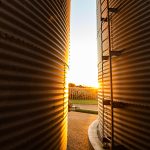 View of sunset between two large grain bins